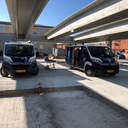 To varevogne parkeret under betonbro